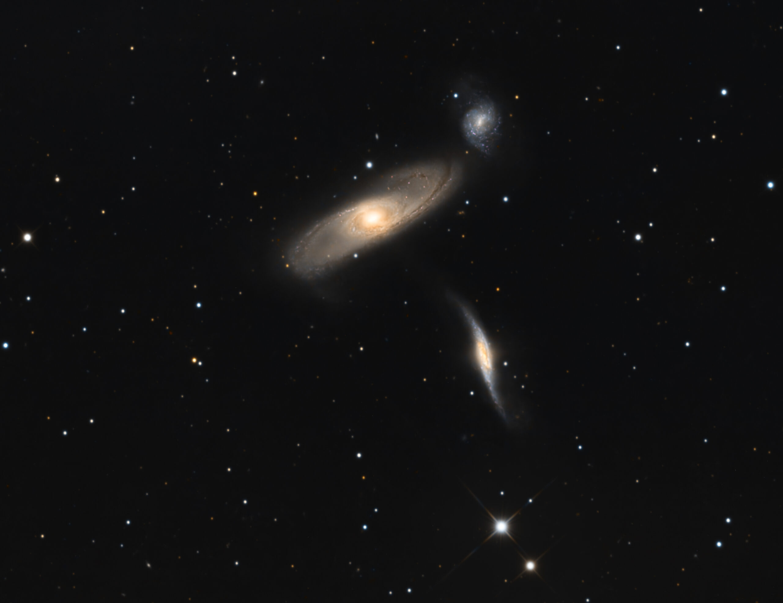 Arp 286: Un Trío Cósmico en Plena Danza Gravitatoria